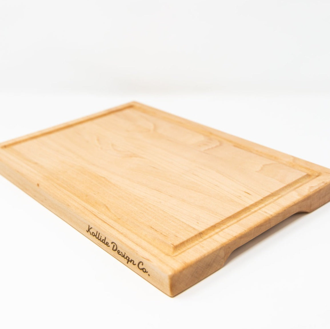 Small wood cutting board, made of light blonde maple, with a juice groove, side handles and