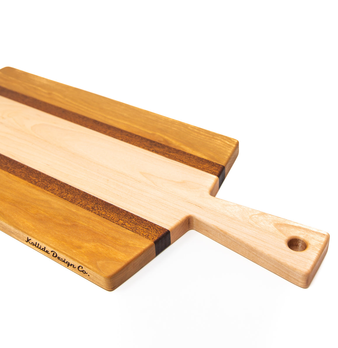 Large size wood charcuterie board, made of golden-brown Cherry, reddish brown Sapele and a center piece of light blonde Maple with a slightly tapered handle and a long rectangular body.
