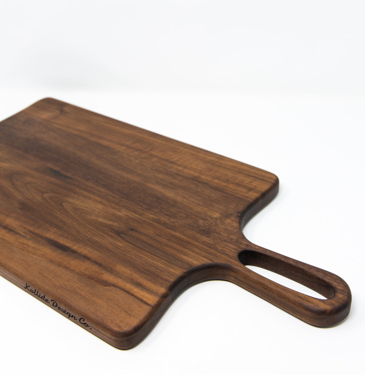 Medium size wood charcuterie board, made of a dark Walnut, with unique looped handle and exaggerated curves.