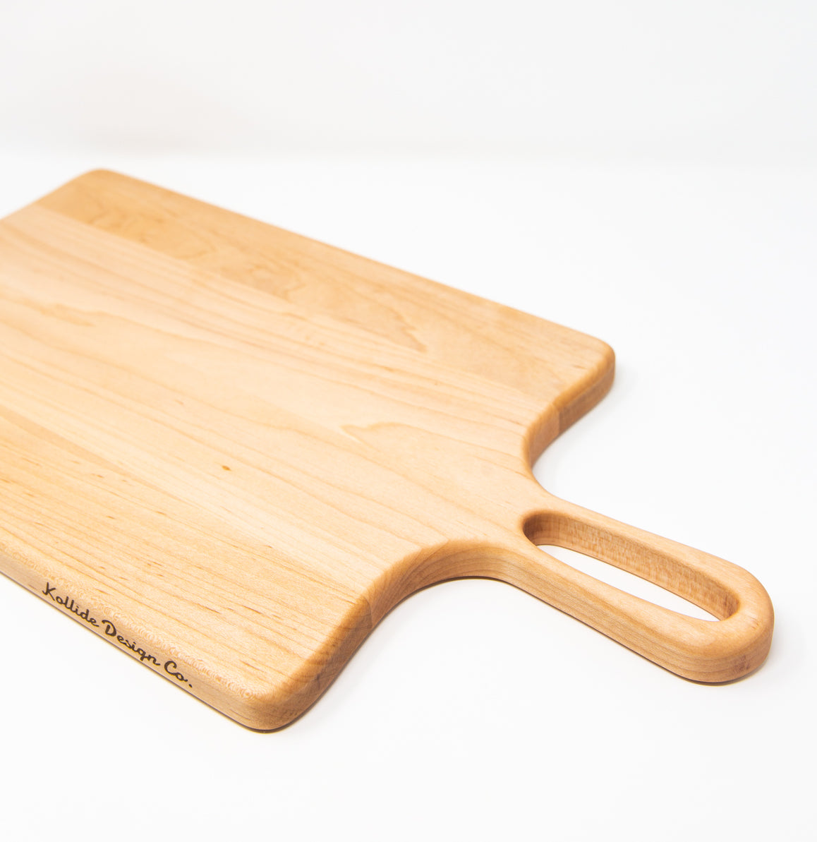 Medium size wood charcuterie board, made of light blonde Maple, with unique looped handle and exaggerated curves.
