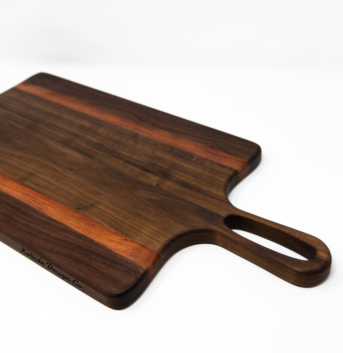 Medium size wood charcuterie board, made of a dark Walnut and two strips of dark reddish-brown Bubinga, with unique looped handle and exaggerated curves.