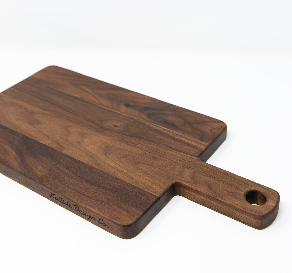Small wood charcuterie board, made of dark Walnut, with a timeless rectangular shape and a straight handle.