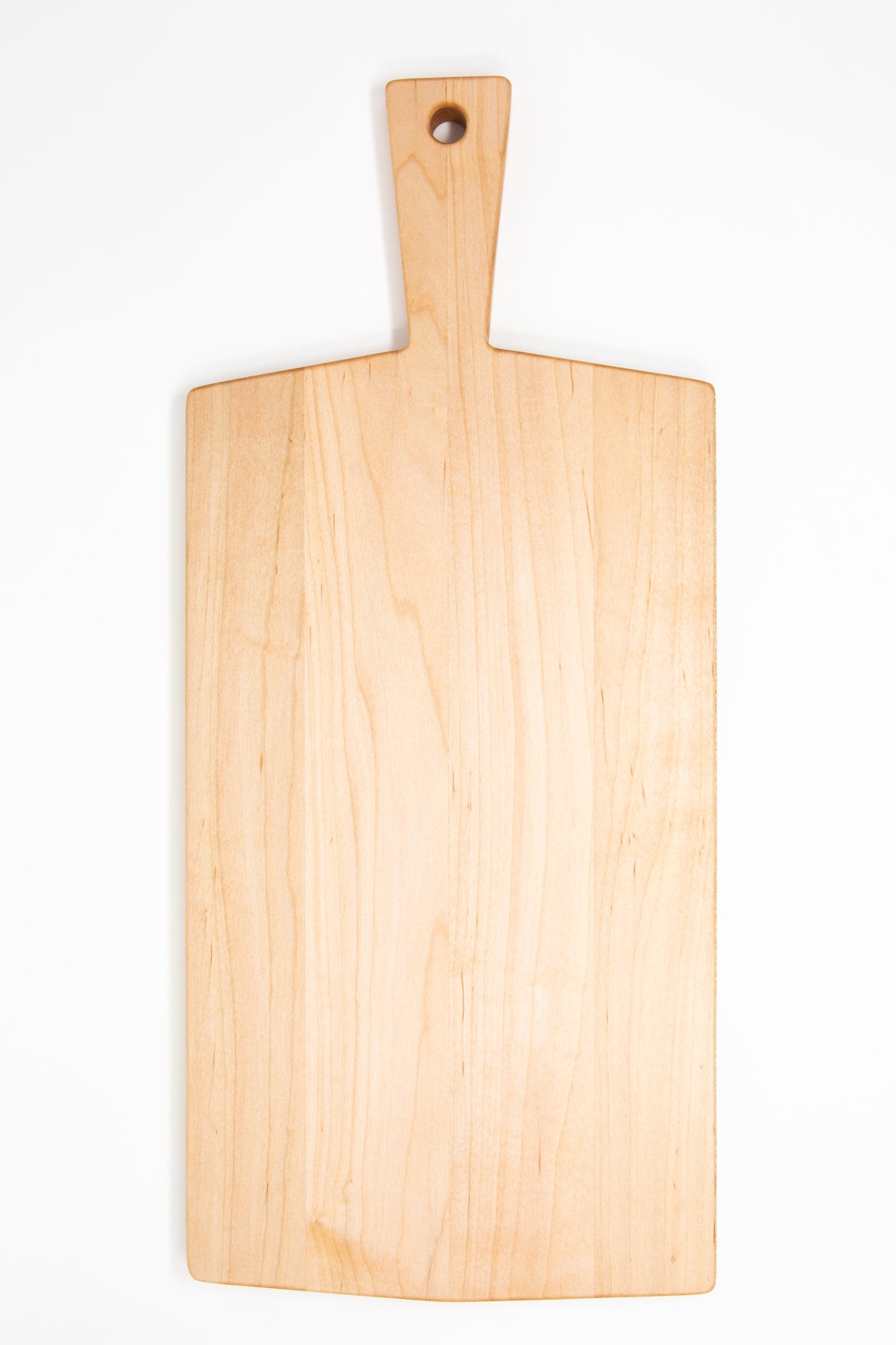 Large size wood charcuterie board, made of light blonde Maple, with a slightly tapered handle and a long rectangular body.