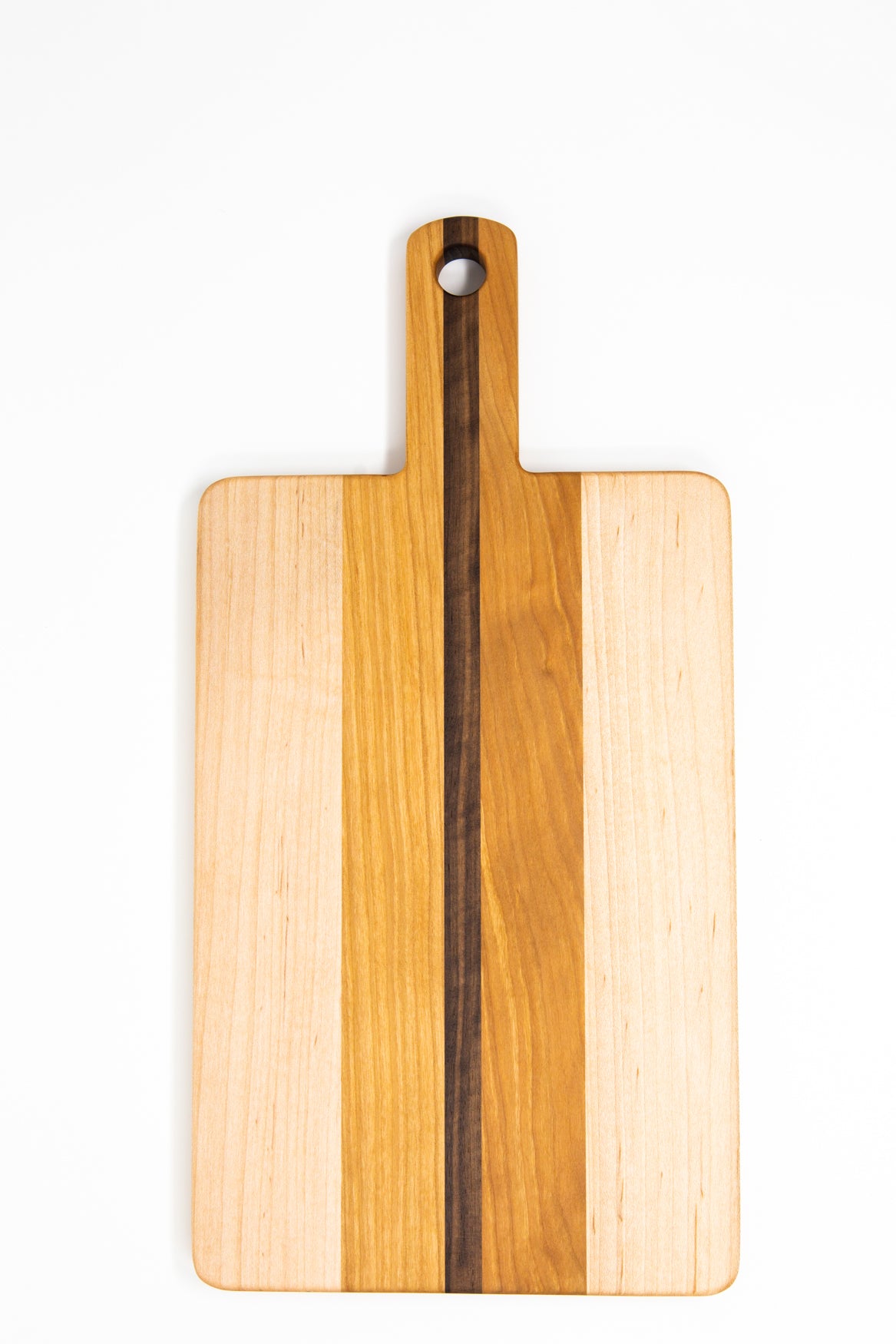 Small wood charcuterie board, made of light blonde Maple, golden-brown Cherry and a center strip of dark Walnut, with a timeless rectangular shape and a straight handle.
