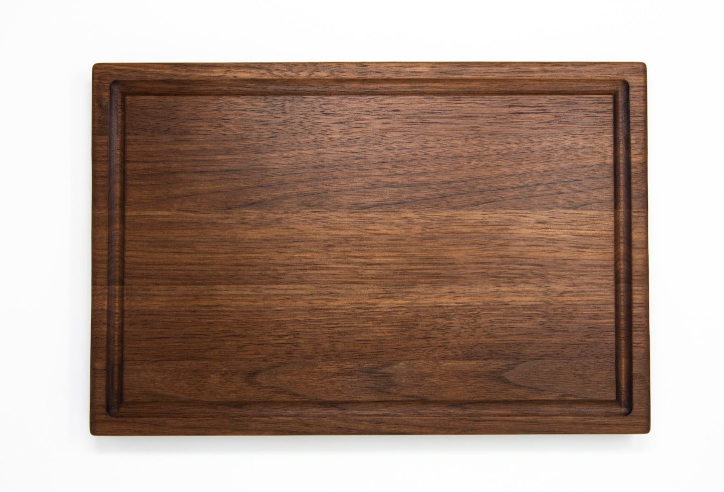 Extra large wood cutting board, made of dark Walnut, with a juice groove and side handles.