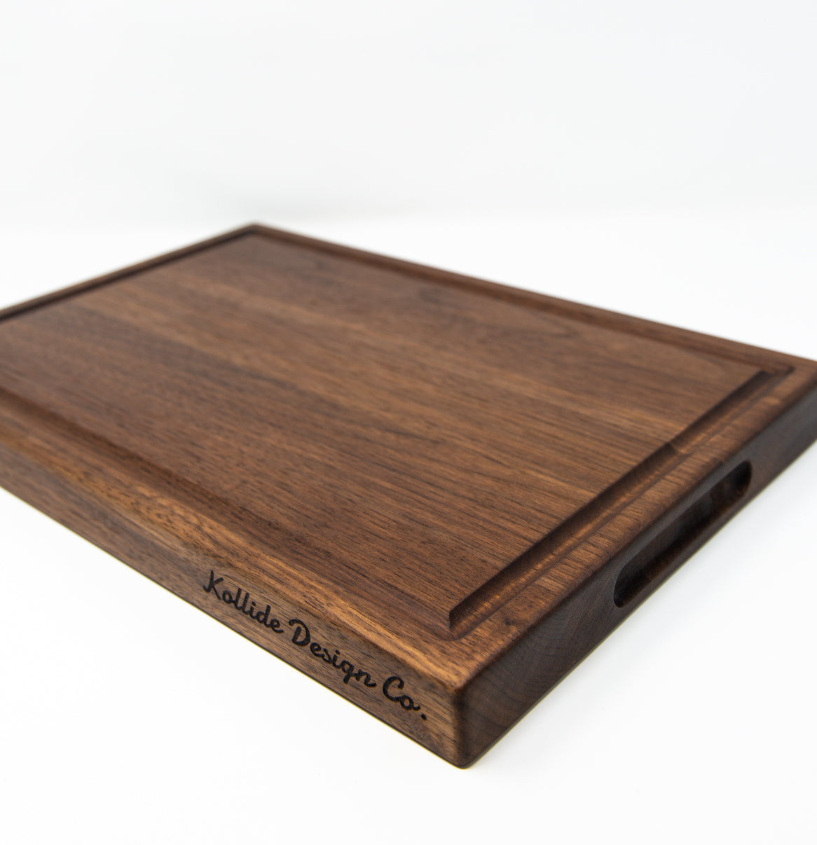 Large size wood cutting board, made of dark Walnut, with a juice groove and side handles.