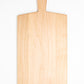 Large size wood charcuterie board, made of light blonde Maple, with a slightly tapered handle and a long rectangular body.
