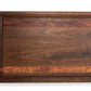 Medium size wood cutting board, made of dark walnut and two strips of dark reddish brown Bubinga, with a juice groove and side handles.