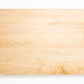 Medium size wood cutting board, made of light blonde Maple, with side handles.