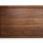 Medium size wood cutting board, made of dark walnut, with a juice groove and side handles.