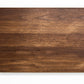 Medium size wood cutting board, made of dark walnut, with side handles.